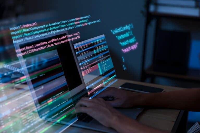 A person typing on a laptop with translucent, floating code windows and multiple screens displaying colorful programming code.